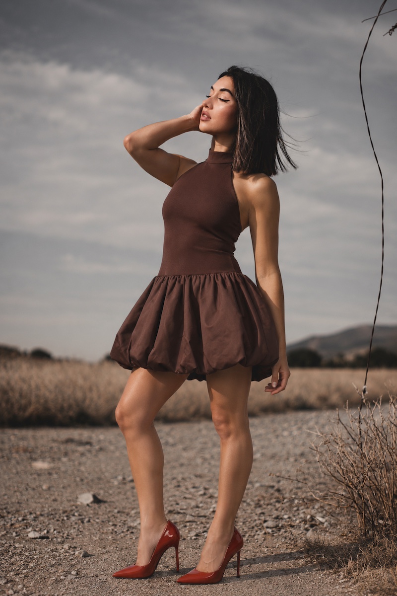 Model in a brown dress and red heels